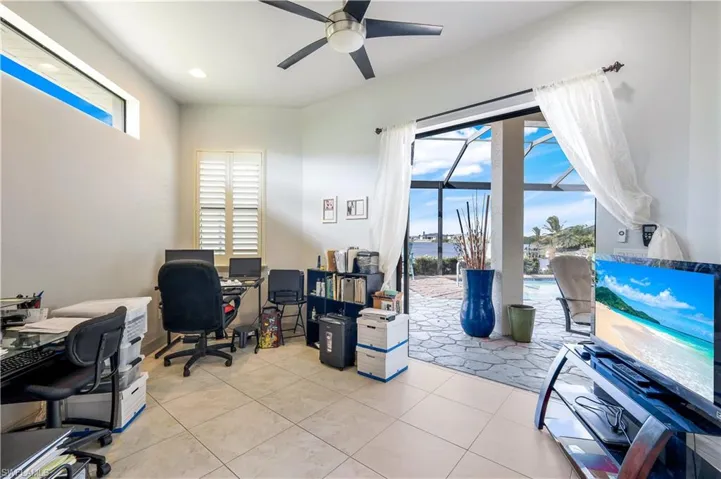 Office space with ceiling fan and light tile patterned flooring