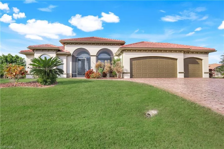 Mediterranean / spanish house featuring a garage and a front lawn