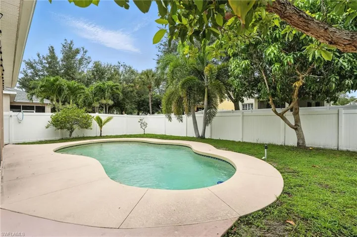 View of swimming pool with a patio area and a fenced backyard