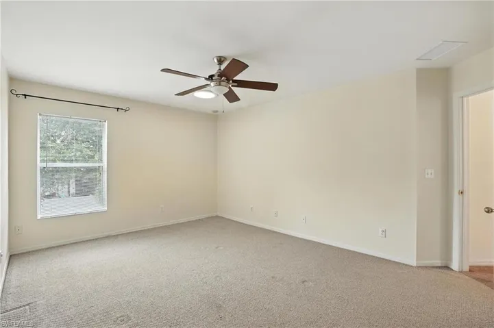 Spare room with light carpet and ceiling fan