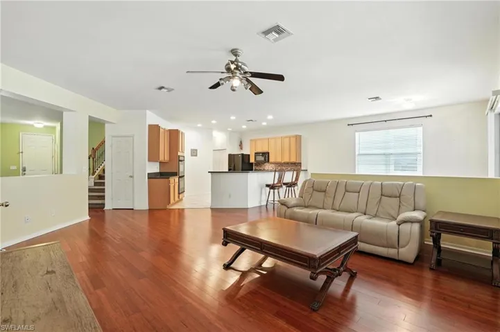 Living area featuring ceiling fan, wood finished floors, stairway, and recessed lighting