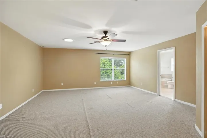 Unfurnished master bedroom with ceiling fan and light colored carpet