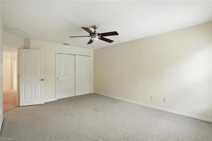 Unfurnished bedroom with carpet, a closet, and ceiling fan