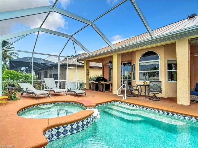 View of swimming pool featuring a patio area, a grill, a ceiling fan, and a pool with connected hot tub