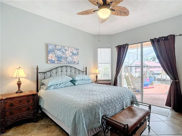 Tiled bedroom with access to exterior and ceiling fan