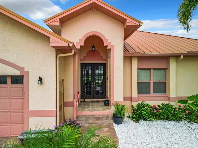 View of exterior entry featuring french doors and stucco siding
