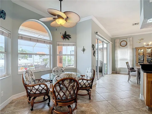 Dining area featuring crown molding, healthy amount of natural light, and a ceiling fan