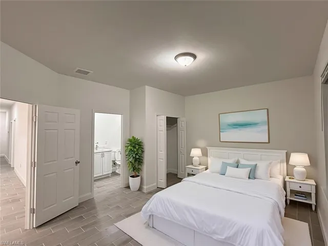 Bedroom with a closet, wood tiled floors, and ensuite bathroom