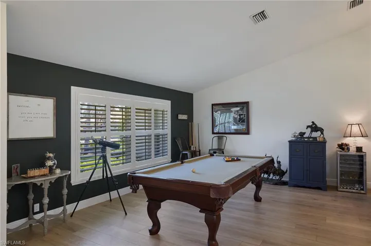 Game room with lofted ceiling, wood like finished floors and billiards