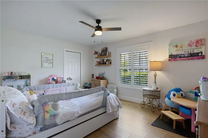 Bedroom featuring ceiling fan, baseboards, and wood like finished floors