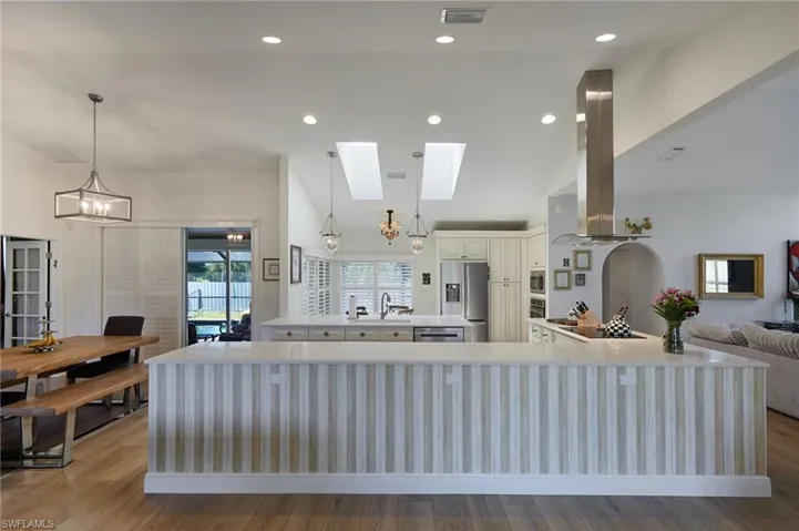 Kitchen featuring a chandelier, light countertops, stainless steel appliances, and island exhaust hood