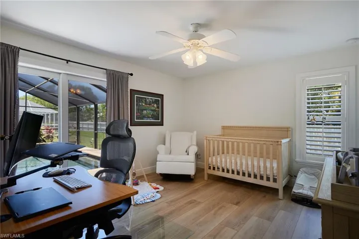 Bedroom with a ceiling fan, wood like finished floors, and baseboards