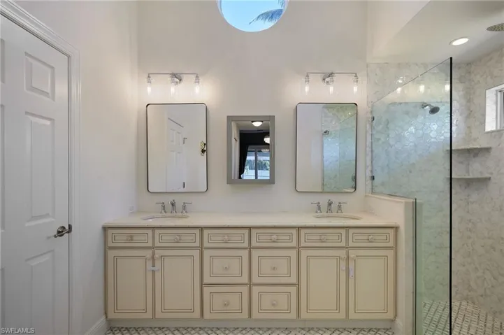 Full bathroom featuring double vanity, a sink, and a walk in shower