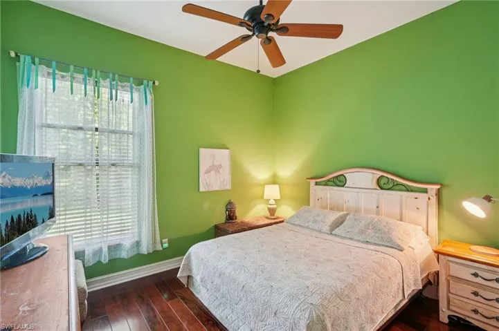 Bedroom with dark wood finished floors and ceiling fan