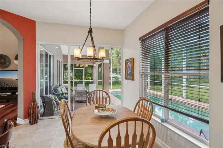 Dining space with a chandelier, tile patterned floors, and arched walkways