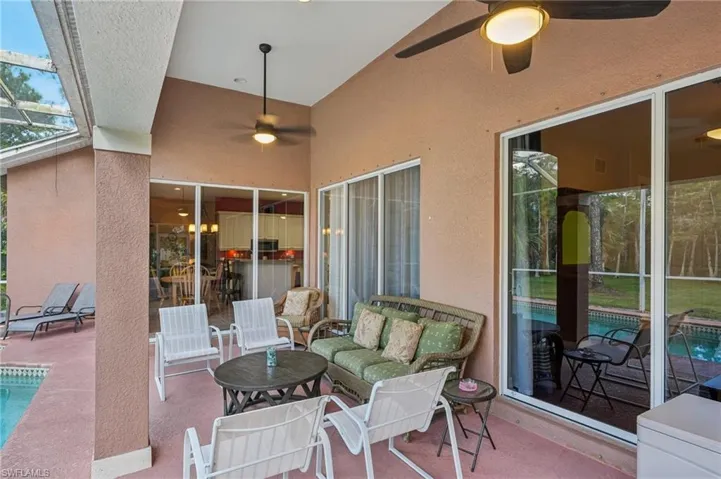 View of patio / terrace with ceiling fan, an outdoor pool, glass enclosure, and a sunroom