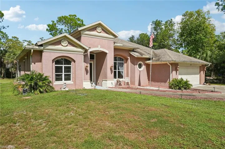 View of front facade featuring a front yard and stucco siding