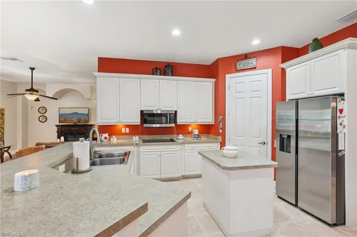 Kitchen featuring a center island, appliances with stainless steel finishes, white cabinetry, light countertops, and recessed lighting