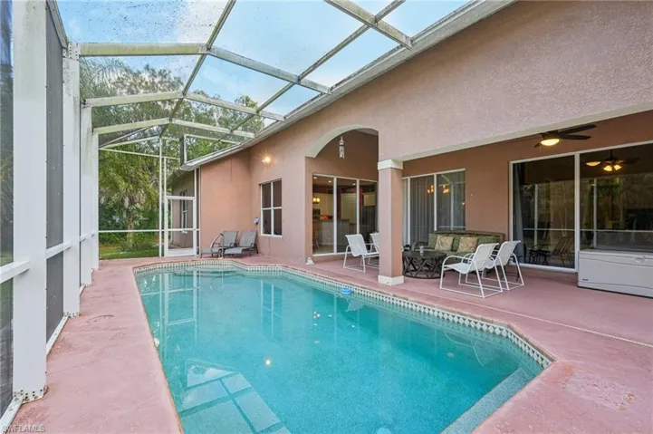 Swimming pool with a patio, a sunroom, and glass enclosure
