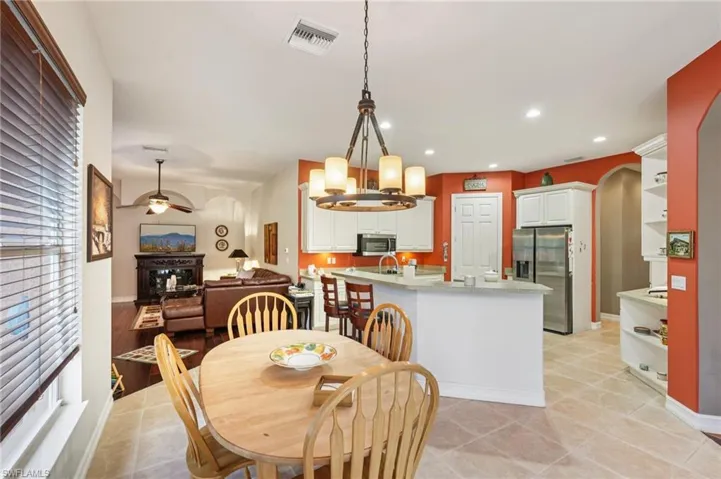 Dining room featuring a chandelier, arched walkways, ceiling fan, light tile patterned floors, and recessed lighting