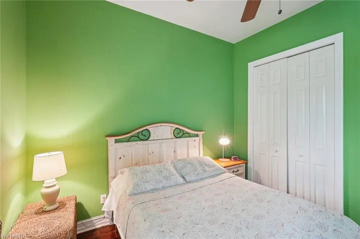 Bedroom with a closet, ceiling fan, and dark wood-type flooring