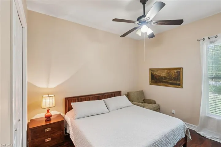 Bedroom with dark wood-style flooring and a ceiling fan
