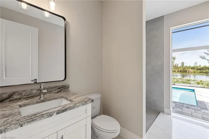Bathroom with a water view, vanity, toilet, and tile flooring
