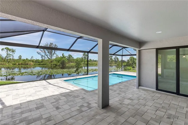 View of pool with a patio, a lanai, and a water view
