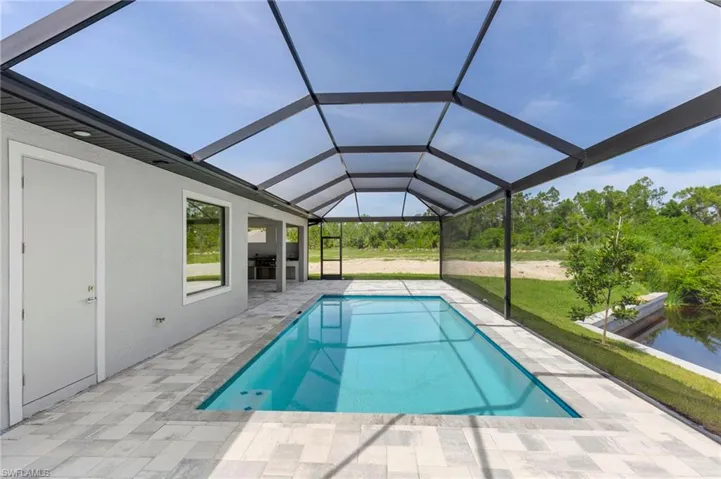View of swimming pool featuring a patio and glass enclosure