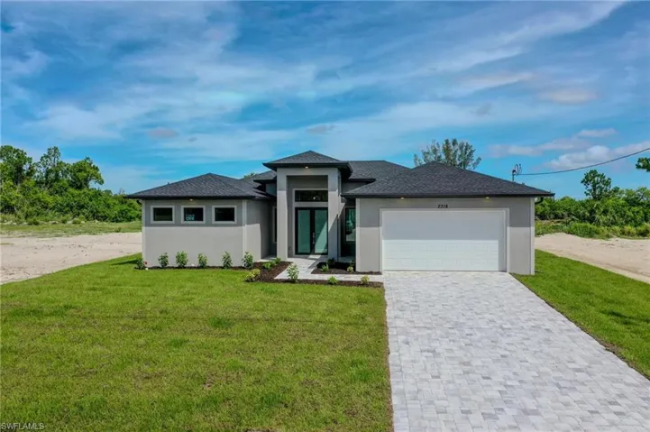 Prairie-style home with a garage and a front lawn