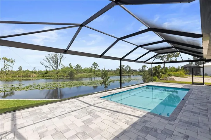 View of pool featuring a patio area, a lanai, and a water view