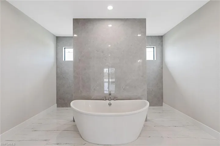 Bathroom featuring tile walls, a healthy amount of sunlight, and tile flooring