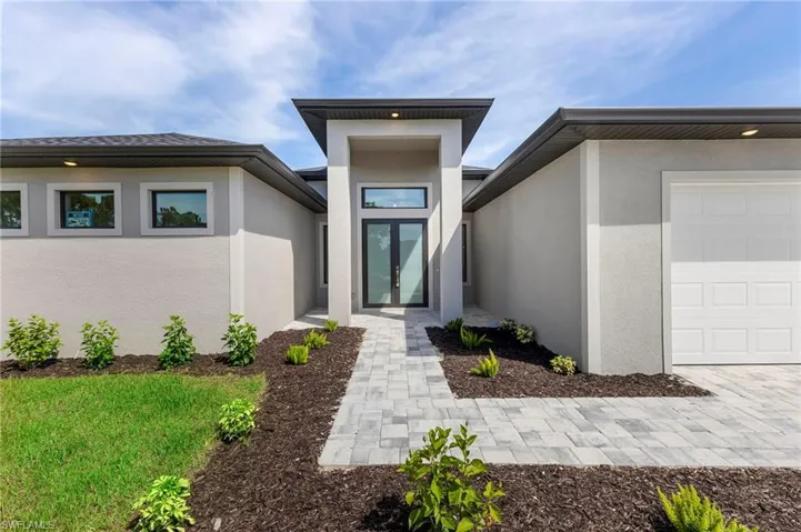 Property entrance featuring french doors and a garage