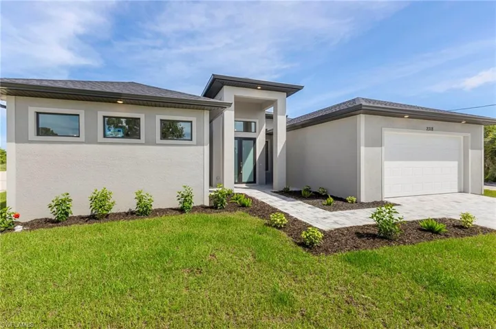 View of front of property featuring a garage and a front yard