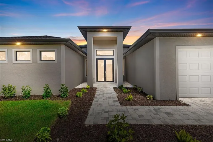 Exterior entry at dusk with a garage