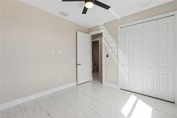 Unfurnished bedroom featuring a closet, ceiling fan, and light tile floors