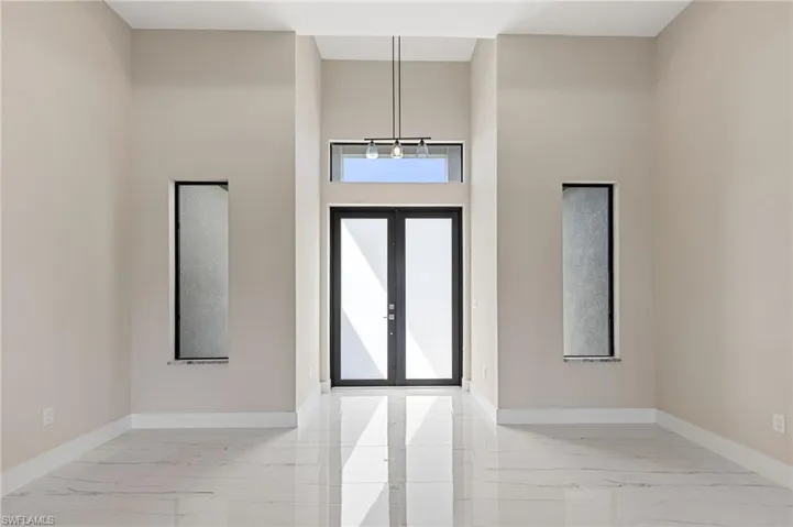 Foyer entrance featuring a towering ceiling and light tile floors