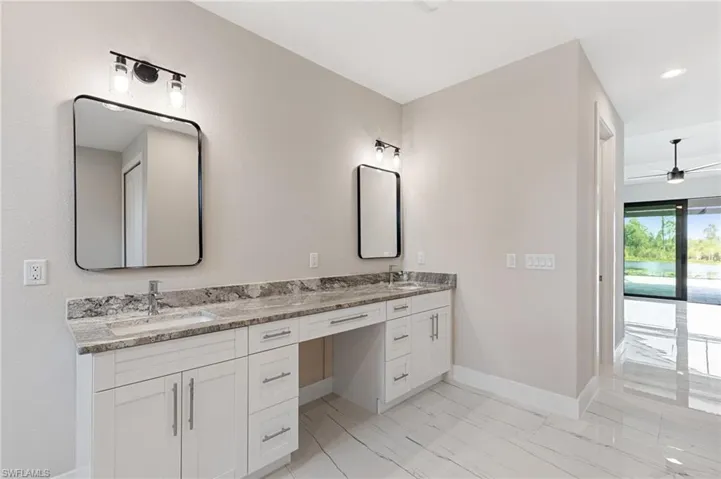 Bathroom featuring tile floors, large vanity, double sink, and ceiling fan