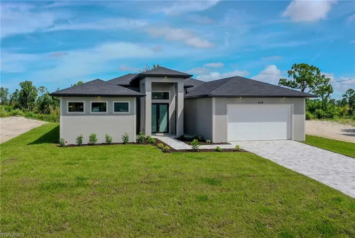 Prairie-style home featuring a garage and a front lawn