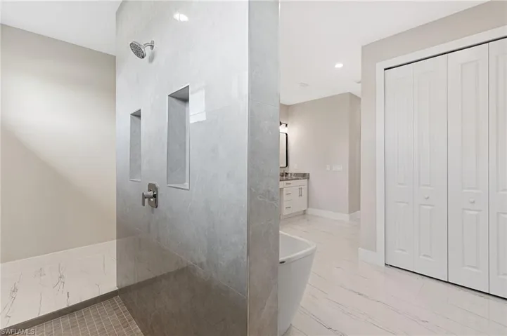Bathroom with tile flooring, vanity, and a bath