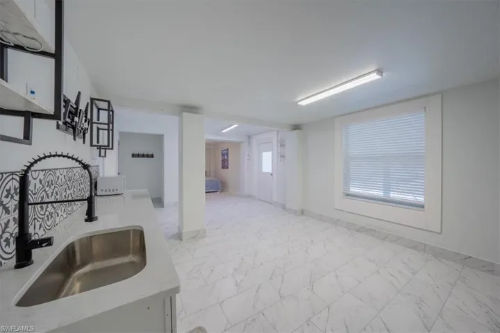 Apartment kitchen featuring a sink, marble finish flooring, and light countertops