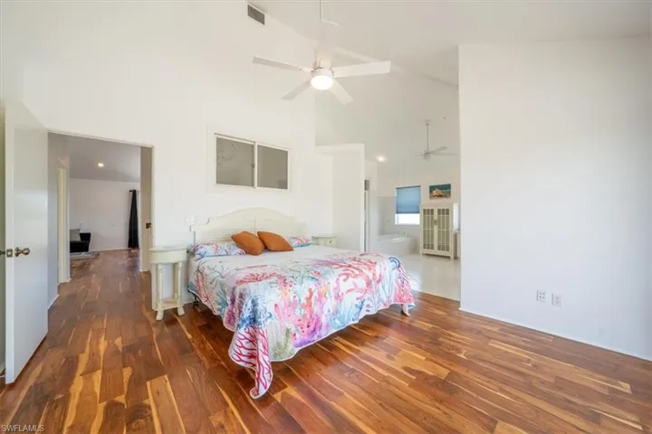Bedroom featuring high vaulted ceiling, wood finished floors, and ceiling fan