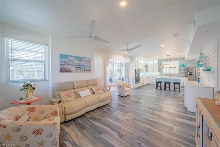 Living area with wood finished floors, a ceiling fan, and recessed lighting