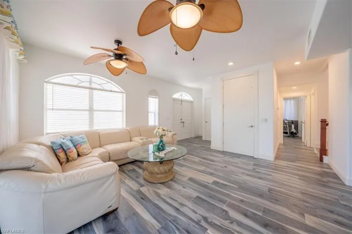 Living room featuring ceiling fan, wood looking tile floors, recessed lighting, and baseboards