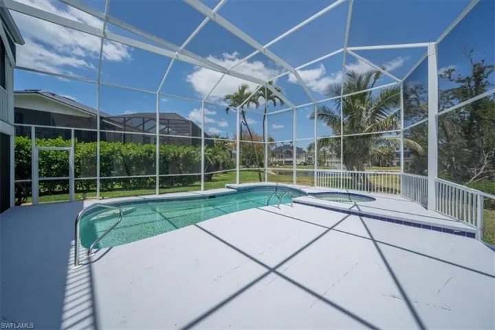 Swimming pool with an in-ground hot tub, a patio area, and screen enclosure