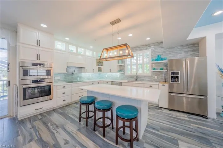 Kitchen featuring stainless steel appliances, open shelves, decorative backsplash, healthy amount of natural light, and recessed lighting