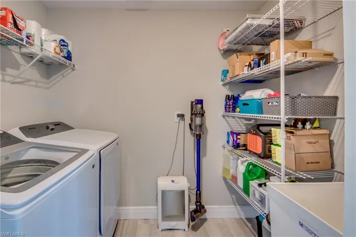 Washroom with washer and clothes dryer and light wood finished floors