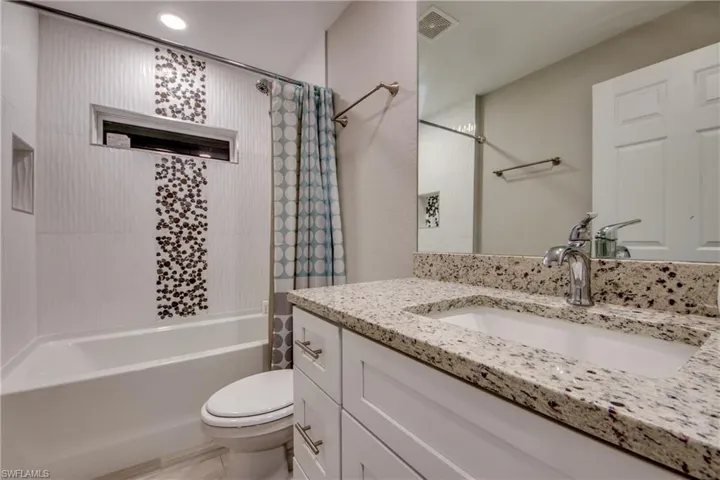 Bathroom with vanity and shower / bath combo with shower curtain