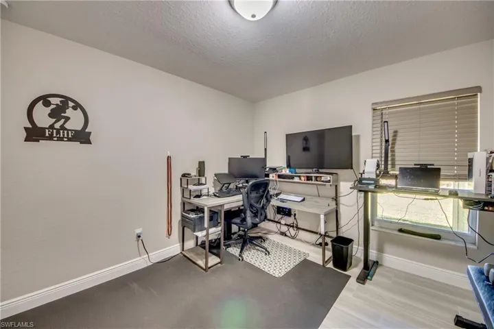 Home office featuring a textured ceiling and baseboards