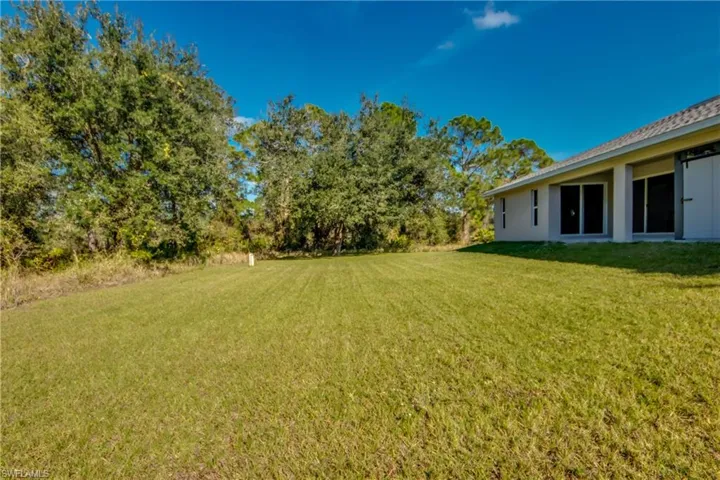 View of grassy yard featuring a patio